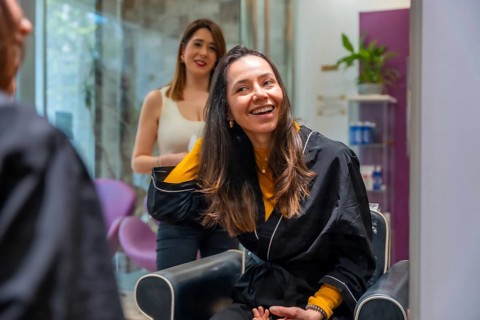 Happy woman smiling and enjoying her new style after a hair treatment at a beauty salon, feeling