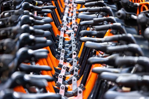 Rows of rental bikes and sharing bicycles parked in the city downtown ready for city commute. Ride