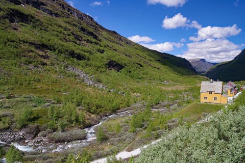 A secluded house in the valley surrounded by green mountains and a flowing river, Rallarveien,