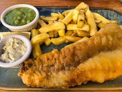 Fish and chips, fried fish in batter, french fries, pea puree, remoulade, on a plate, greasy, food,