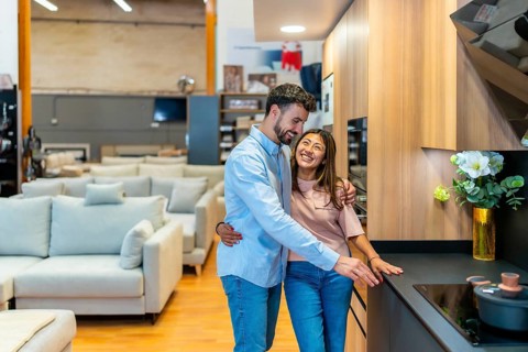 Young couple exploring kitchen design options in a modern showroom, planning home renovation and