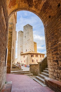 Towers of the old Town with historic buildings from Piazza del Duomo at San Gimignano on a sunny