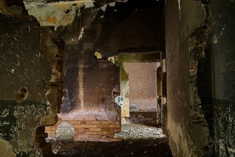 Abandoned ruin with broken walls and a dark, partially collapsed passage, Lost Place, Tourtouras