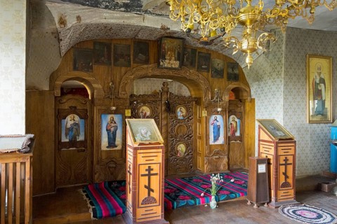 Orthodox altar with icons and a golden chandelier in a decorated chapel, cave church, rock caves,