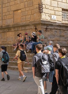 Tourists around the market square with old fountain and other sights in San Gimignano, Tuscany,