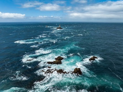 Aerial view of the wild foaming sea at Pointe du Raz with the offshore Phare de la Vieille