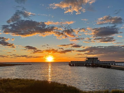 Colourful sunset at sea with jetty and dramatically illuminated clouds, Borgholm, Öland, Sweden