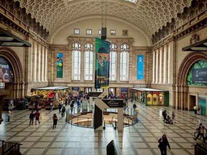 Light-flooded station hall with people and tourist shops, train station, Leipzig main station