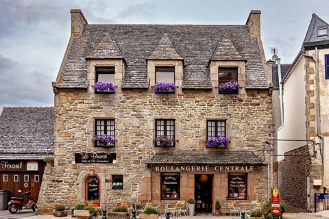 Stone commercial building with flower boxes and signs, traditional atmosphere, historic stone house