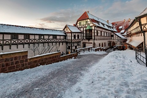 Snowy courtyard of a timber-framed castle under a clear sky, The Wartburg near Eisenach in