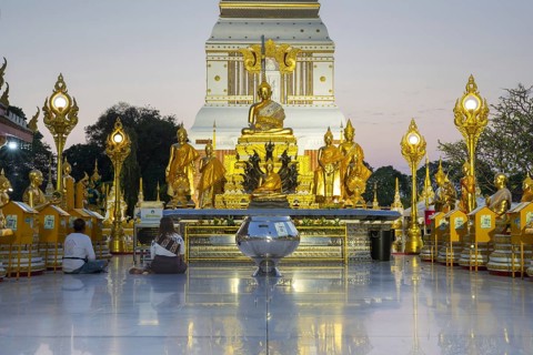 Chedi decorated with golden ornaments at Wat Phra That Phanom at sunset, temple complex in Amphoe