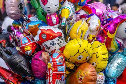 Many colorful motif balloons, filled with gas, float, with many different motifs, some comic
