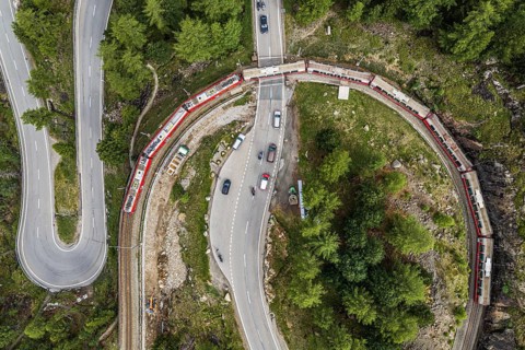 Red train of the Rhaetian railroad line, Bernina Express, 180 degree turn at the Montebello curve,