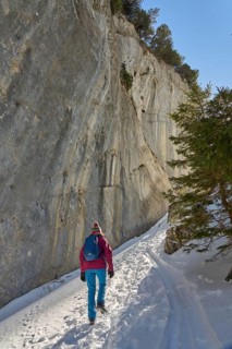Woman hiking in the snowy mountain landscape of the Alpstein Säntis mountain range, Brülisau,