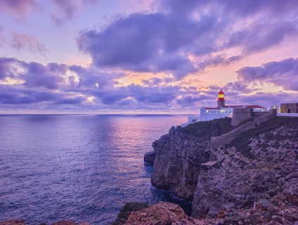 View of the Lighthouse of Cabo de Sao Vicente in Sagres, Algarve, Portugal, at dusk with rugged