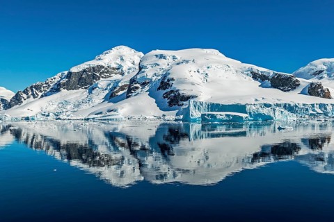 Snow-capped peaks and glaciers reflected in calm waters, Gerlache Strait, Antarctica