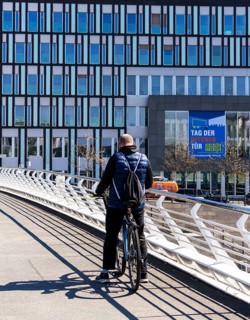 Cyclists on the Crown Prince Bridge with a view of the House of the Federal Press Conference,