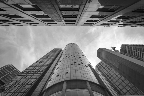 Drmatic black and white image of tops of skyscrapers with main observation tower in the middle,