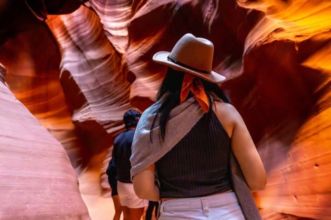 Tourist walks through the narrow antelope canyon, marveling at the swirling sandstone walls