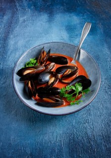 Fra Diavolo mussels, mussels in tomato sauce, Italian dish, on a blue background, homemade, no