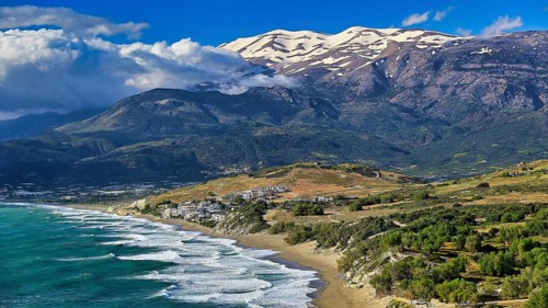 Komos Beach, impressive panoramic view of a beach, sea and snow-capped mountains, Matala, south