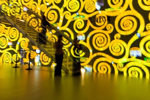 Swirling patterns, spirals, gold, yellow, immersive exhibition, digital art, colorful projections