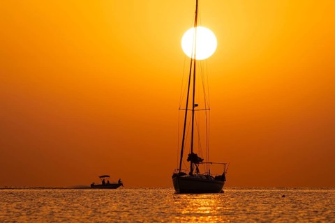 The sun rises on the horizon over the sea in Sardinia, Sardinia Italy