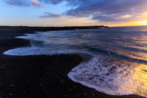 Lanzarote, Canary Islands, Spain, Europe, Los Hervideros, waves gently wash the beach at sunset,