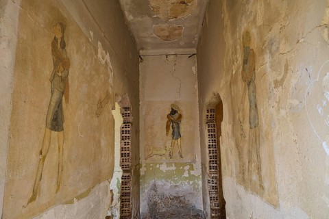 A narrow corridor with faded vintage style murals surrounded by shabby old walls, Lost Place,