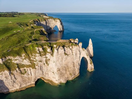 Aerial view of the Porte d'Aval rock formation with the free-standing Aiguille d'Étretat rock pin