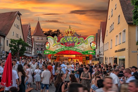 Visitors at the stand with fresh Hungarian flatbread at the Laufer City Festival, evening sky, Lauf