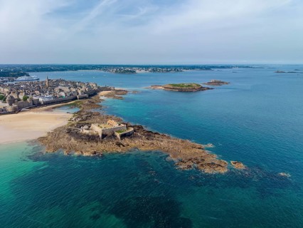 Aerial view of the historic Fort National island fort on the sandy beach of Saint Malo at low tide.