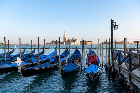 Venetian gondolas, boat launch at St. Mark's Square, San Giorgio Maggiore church in the evening