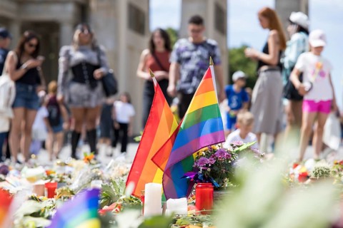 Rainbow flags in an improvised memorial made of flowers and candles on Pariser Platz in front of