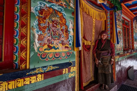 Elderly woman, Buddhist nun in front of Buddhist monastery, Ripchet, Tsum Valley, Himalayas, Nepal