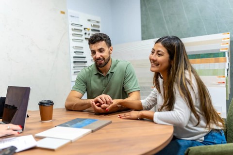 Couple consulting with an expert at a home improvement store, choosing new tiles and materials for