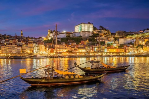 Blue hour night scene of Porto rabelo boats on Douro River by Ribeira, Portugal, with evening