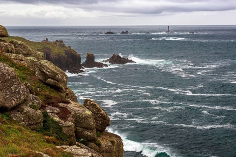 The rugged cliffs of Land's End in Cornwall with a view of the historic Longships lighthouse in the