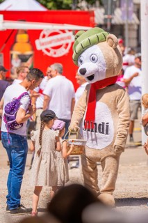 Child interacts with a bear mascot, feeling joy and lightness at a lively event, VFB im Ländle
