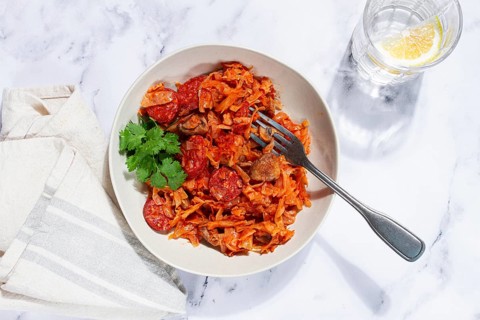 Bigos, Polish dish bigos, on a marble table, stewed meat with cabbage, chorizo sausages, mushrooms,
