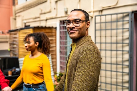 Diverse group of people connecting, holding hands, and smiling during an outdoor therapy session,