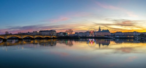 Bayonne cityscape along the adour river at sunset, colorful reflections, illuminated pont saint