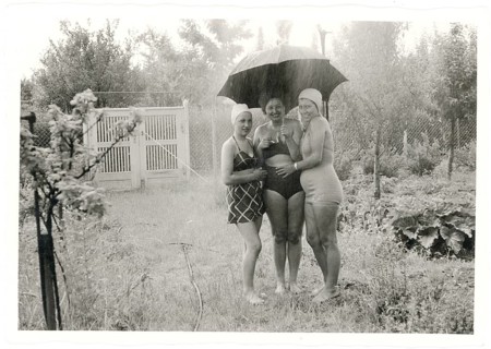 Swimwear, bathing, Three cheerful woman in bathing suits standing under an umbrella in the rain,