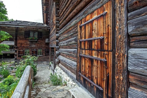 Old farmhouse, now museum, historic mountain farming village Gerstruben, in the back Marienkapelle