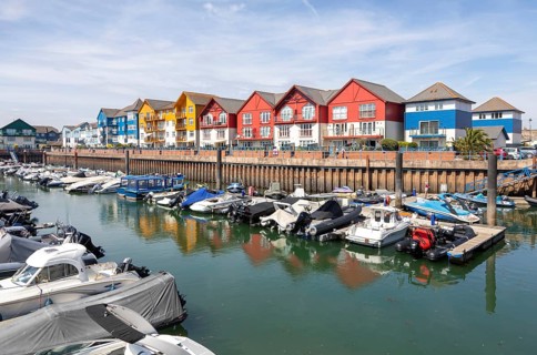 Boats at moorings, modern residential housing development at Exmouth Quay marina, Exmouth, Devon,