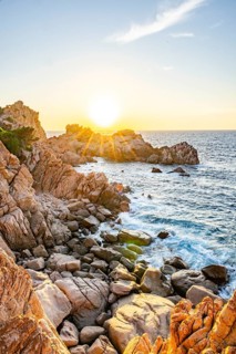 Landscape of the coastline with blue water at Costa Paradiso on a sunny day at sunset, Sardinia,
