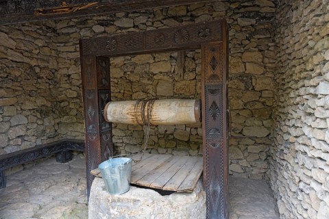 Rustic stone well with bucket in a walled area, historic well, Butuceni, Old Orhei, Orheiul Vechi,