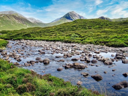 River Sligachan, riverbed with stones, cone-shaped mountain Marsco, Red Cuillin, blue sky, hiking,