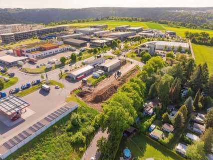 Aerial view of a commercial area surrounded by green landscape, Parkhaus Bau, Calw, Germany