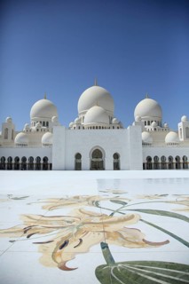 White mosque with filigree floral pattern in the foreground and clear blue sky, Sheik Zayed Mosque,